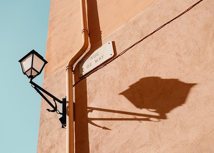 Cuadro de ciudades con farol y sombra en pared