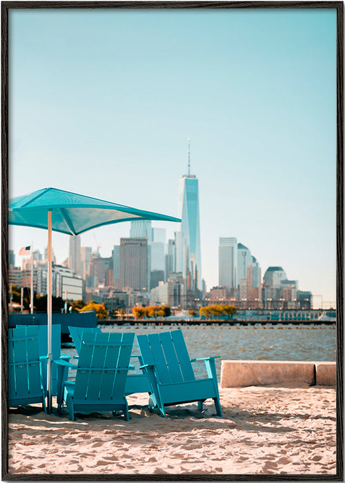 Cuadro de ciudades con sillones turquesa en la playa – Black Frame