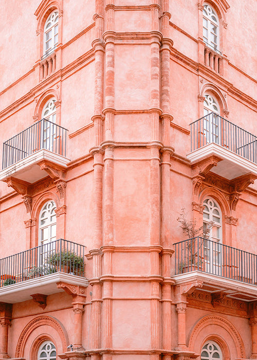 Cuadro de ciudades con fachada rosada y balcones
