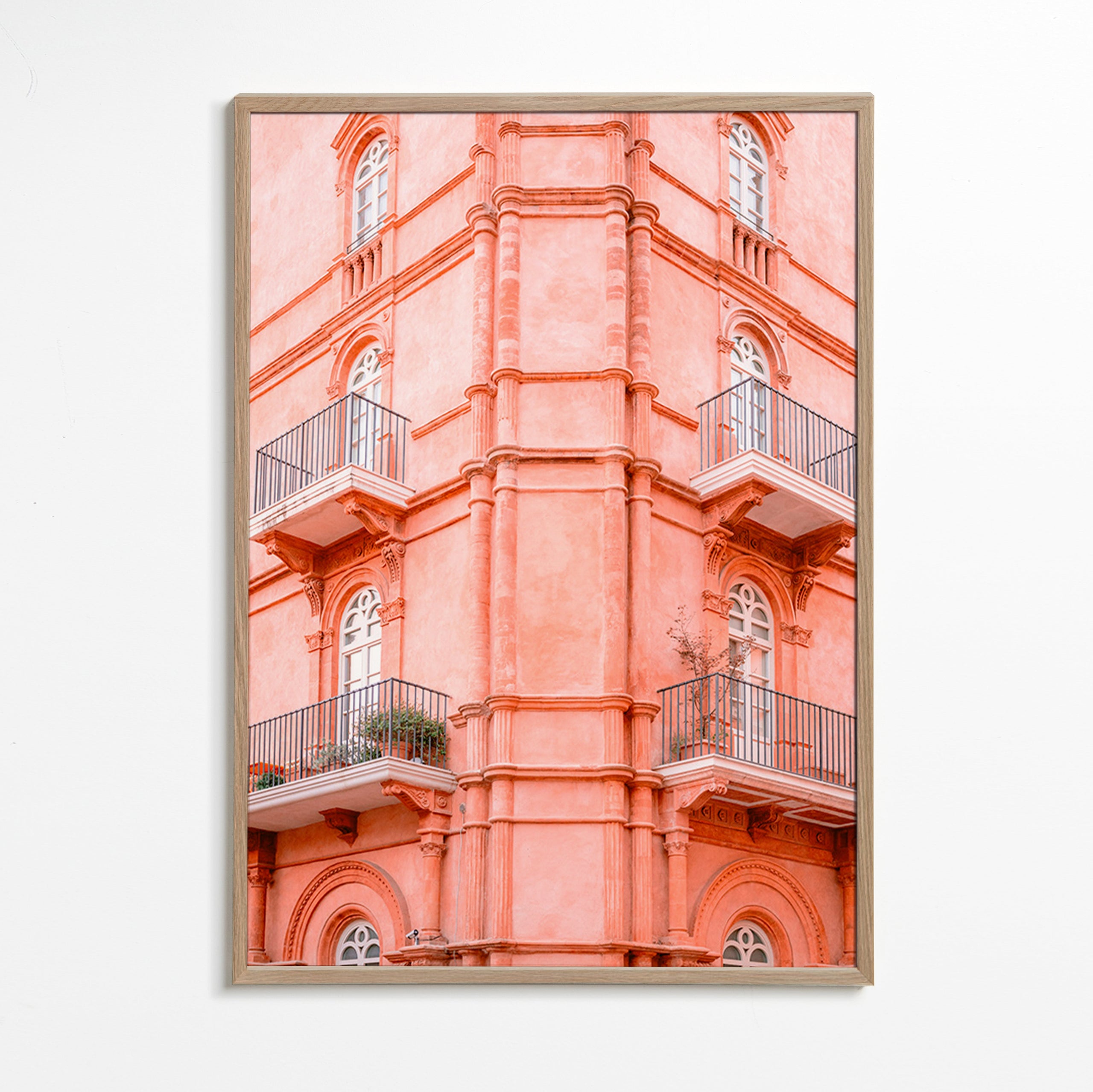 Cuadro de ciudades con fachada rosada y balcones – Oak Frame