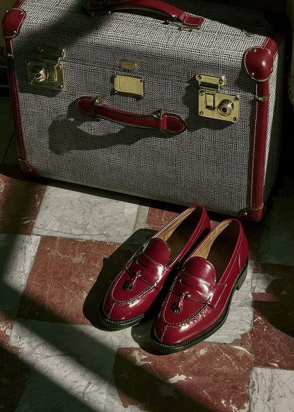 Cuadro de ciudades con maleta y zapatos rojos
